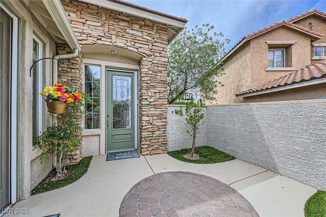 215 Sunset Shower Dr, Henderson, NV 89012 - doorway to property with fence, stucco siding, and stone siding