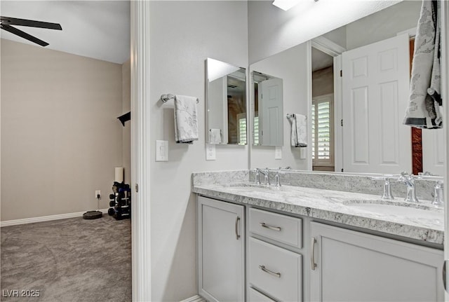 full bathroom featuring double vanity, baseboards, a sink, and a ceiling fan
