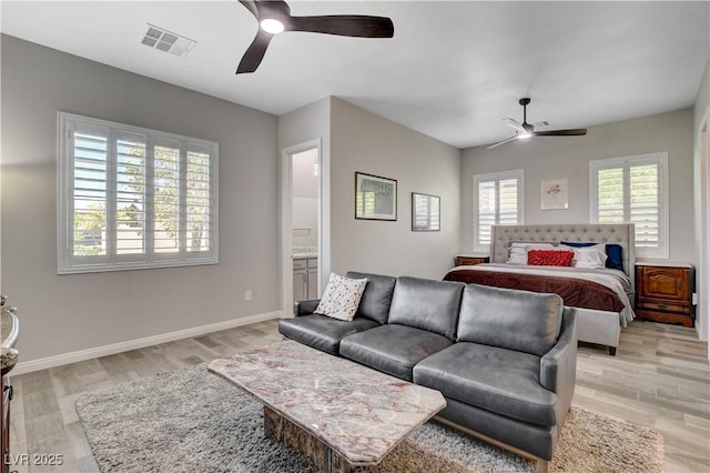 bedroom featuring light wood-style floors, visible vents, baseboards, and ceiling fan