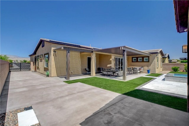 rear view of property featuring a patio, stucco siding, and a fenced backyard