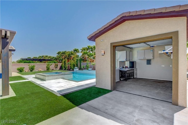view of pool with a fenced backyard, a pool with connected hot tub, a patio, and a lawn