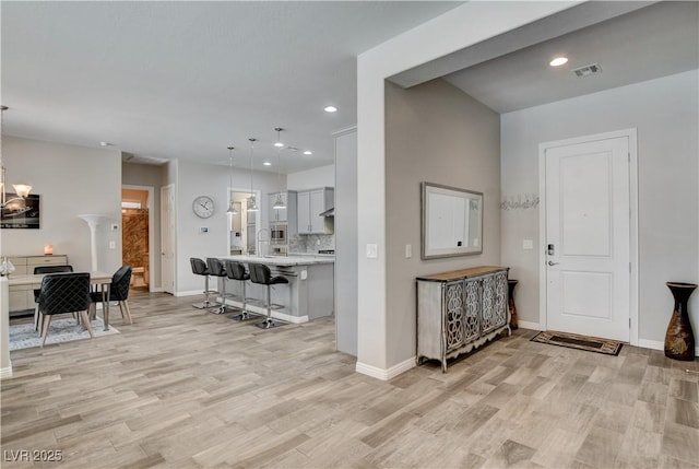 entrance foyer featuring light wood-type flooring, baseboards, a chandelier, recessed lighting, and visible vents