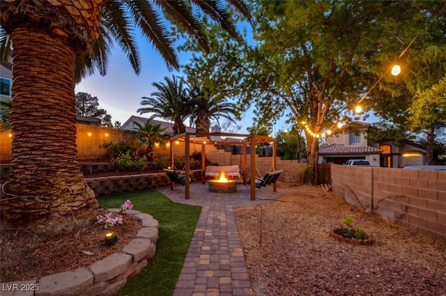 4517 Inez Dr, Las Vegas, NV 89130 - yard at dusk with a fire pit, a pergola, a patio area, and a fenced backyard