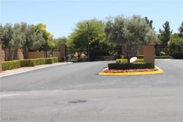 932 Tafalla Ct, Las Vegas, NV 89138 - view of road with street lights, a gated entry, curbs, and a gate