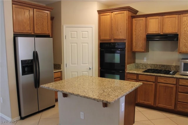 932 Tafalla Ct, Las Vegas, NV 89138 - kitchen featuring brown cabinets, light tile patterned floors, black appliances, and under cabinet range hood