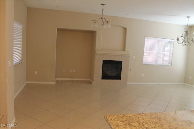 932 Tafalla Ct, Las Vegas, NV 89138 - unfurnished living room with baseboards, an inviting chandelier, a fireplace, and light tile patterned floors