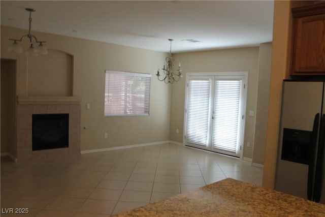 932 Tafalla Ct, Las Vegas, NV 89138 - unfurnished dining area featuring a tiled fireplace, a notable chandelier, baseboards, and light tile patterned flooring