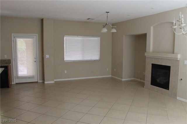 932 Tafalla Ct, Las Vegas, NV 89138 - unfurnished living room with a tiled fireplace, light tile patterned floors, a notable chandelier, and visible vents
