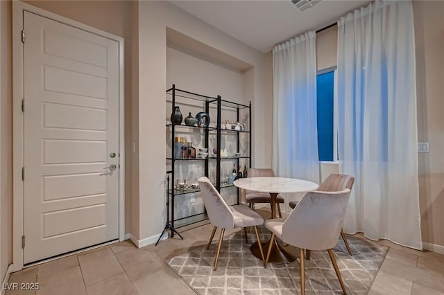 tiled dining area with visible vents and baseboards