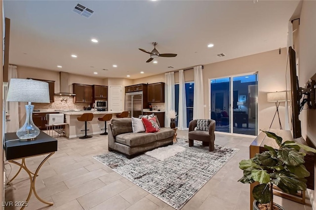 living area with ceiling fan, visible vents, and recessed lighting