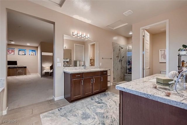 bathroom with a shower stall, tile patterned floors, a sink, baseboards, and two vanities