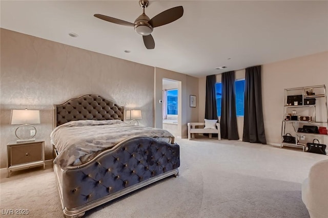 carpeted bedroom with a ceiling fan, visible vents, and ensuite bathroom