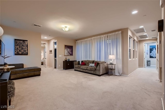 living room featuring baseboards, visible vents, recessed lighting, and light colored carpet