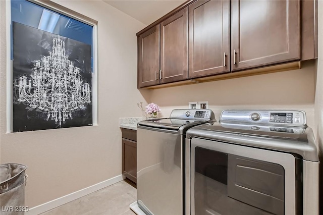 laundry room featuring light tile patterned floors, washing machine and clothes dryer, cabinet space, and baseboards