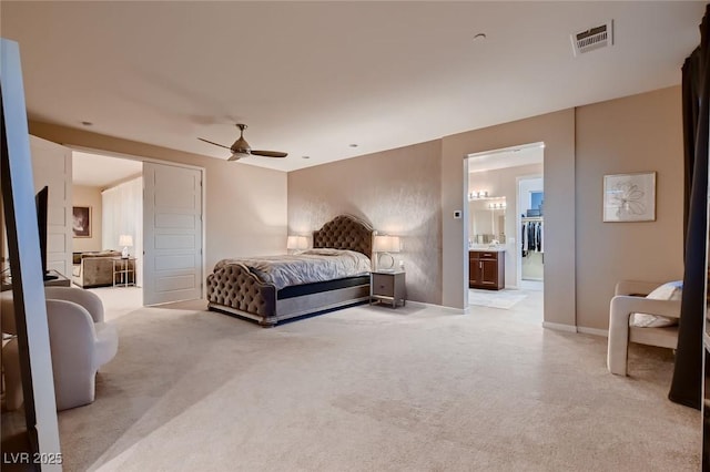 bedroom featuring a ceiling fan, light carpet, baseboards, ensuite bath, and visible vents