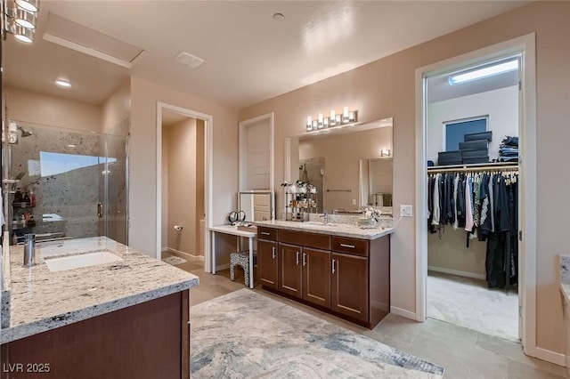 bathroom with tile patterned floors, a sink, a stall shower, baseboards, and two vanities