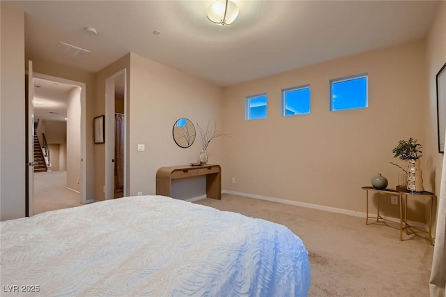 bedroom with light colored carpet and baseboards