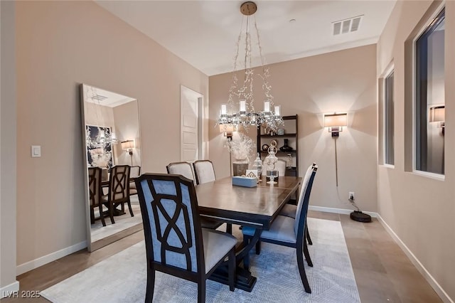 dining area with visible vents, baseboards, an inviting chandelier, and finished concrete flooring