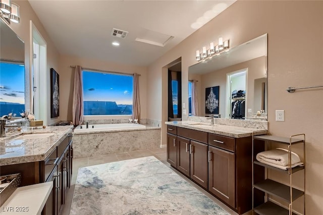 full bath with a sink, a bath, tile patterned flooring, two vanities, and visible vents