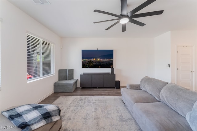 living room featuring a ceiling fan, baseboards, visible vents, and wood finished floors