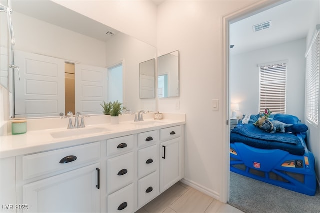 full bath with double vanity, baseboards, visible vents, and a sink
