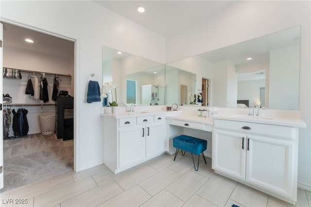 bathroom with recessed lighting, a spacious closet, and vanity