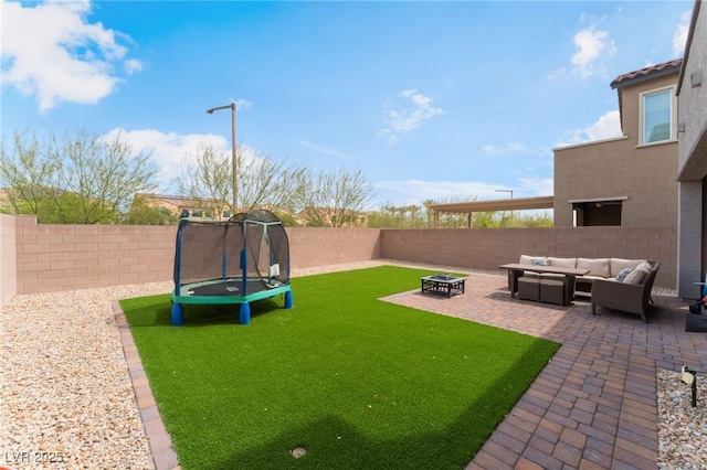 view of yard with a patio, a fenced backyard, a trampoline, and an outdoor living space with a fire pit