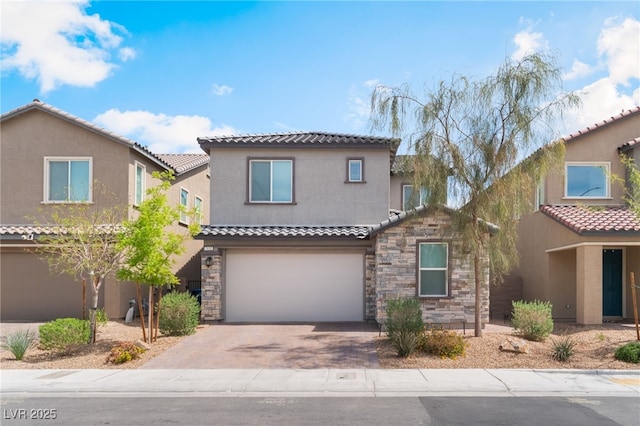 mediterranean / spanish home with a tiled roof, aphalt driveway, an attached garage, stone siding, and stucco siding