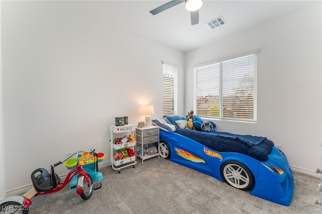carpeted bedroom with visible vents, a ceiling fan, and baseboards