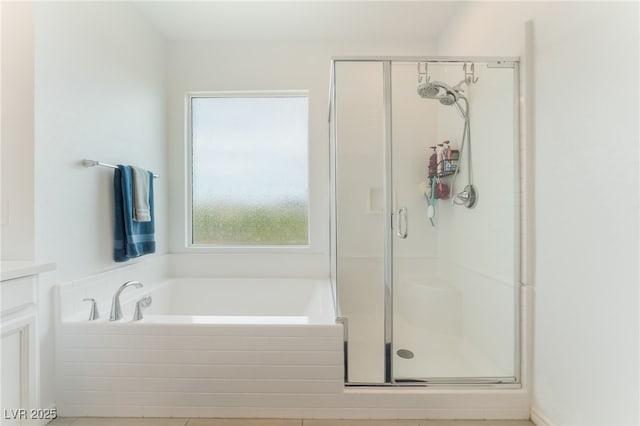 bathroom featuring vanity, a stall shower, and a garden tub