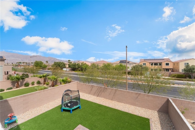 view of property's community with a mountain view, a residential view, and a fenced backyard