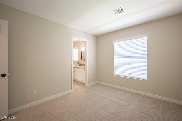 unfurnished room with light carpet, plenty of natural light, and visible vents