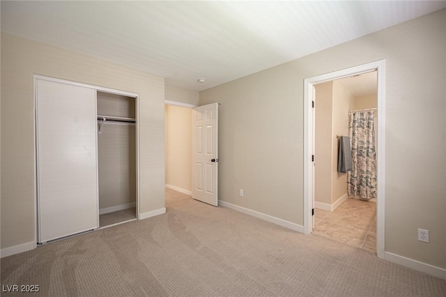 unfurnished bedroom featuring a closet, baseboards, carpet flooring, and connected bathroom
