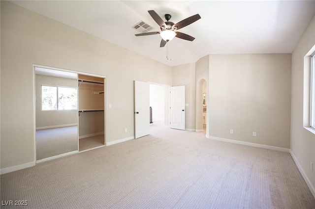 unfurnished bedroom with ceiling fan, arched walkways, visible vents, light carpet, and baseboards