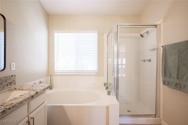 bathroom featuring a bath, a stall shower, and vanity