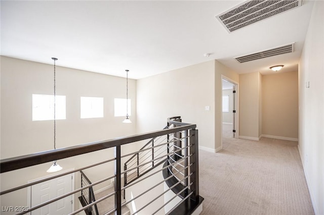 corridor featuring plenty of natural light, visible vents, and carpet floors