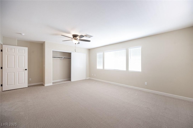 unfurnished bedroom featuring a closet, baseboards, a ceiling fan, visible vents, and light colored carpet
