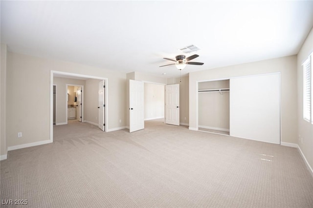 unfurnished bedroom featuring a closet, light colored carpet, a ceiling fan, visible vents, and baseboards