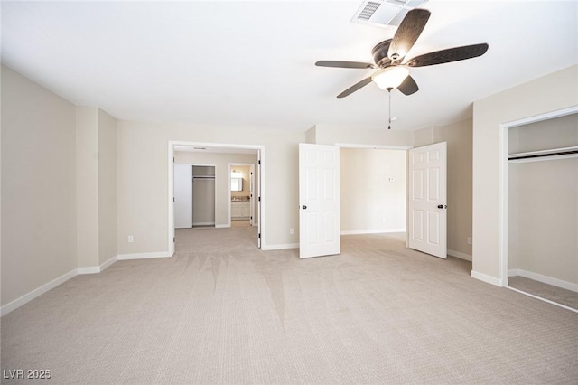 unfurnished bedroom with a closet, baseboards, light carpet, a ceiling fan, and visible vents