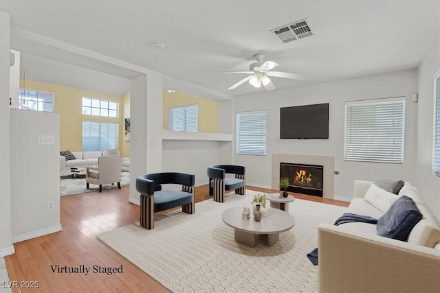 681 Peach Coral St, Las Vegas, NV 89183 - living room with a ceiling fan, visible vents, a fireplace, wood finished floors, and baseboards