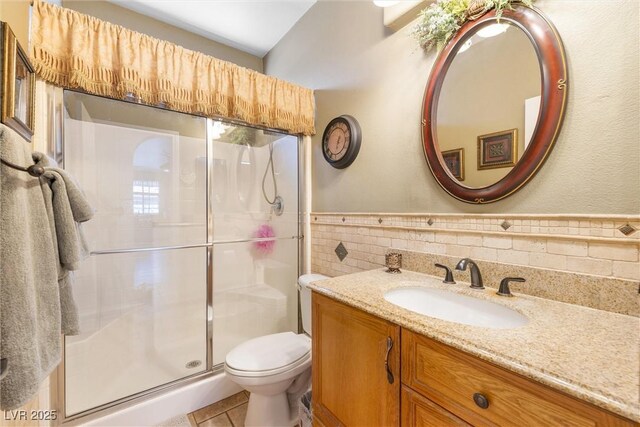 648 Sunrise Lake Pl, Henderson, NV 89002 - bathroom with tile walls, a stall shower, vanity, a wainscoted wall, and toilet