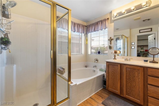 648 Sunrise Lake Pl, Henderson, NV 89002 - bathroom with a garden tub, visible vents, a stall shower, wood finished floors, and vanity