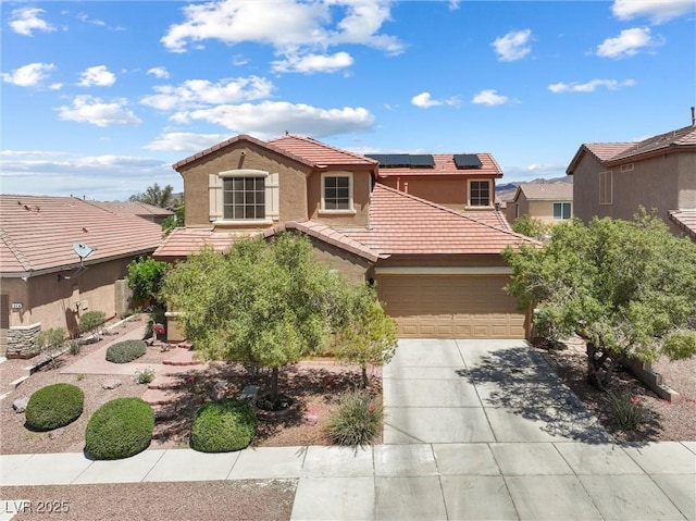 648 Sunrise Lake Pl, Henderson, NV 89002 - mediterranean / spanish-style house featuring an attached garage, a tile roof, stucco siding, roof mounted solar panels, and driveway