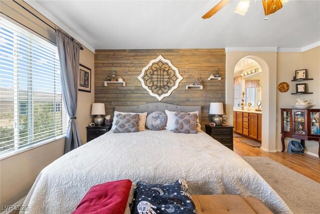648 Sunrise Lake Pl, Henderson, NV 89002 - bedroom with crown molding, wood walls, an accent wall, baseboards, and light wood-type flooring