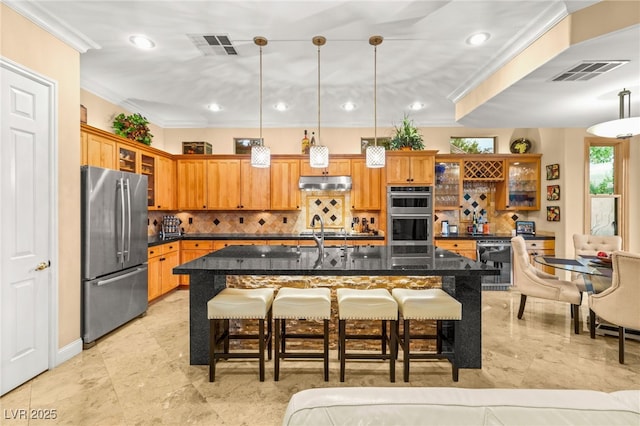 9 Contra Costa Pl, Henderson, NV 89052 - kitchen with under cabinet range hood, decorative backsplash, appliances with stainless steel finishes, and visible vents