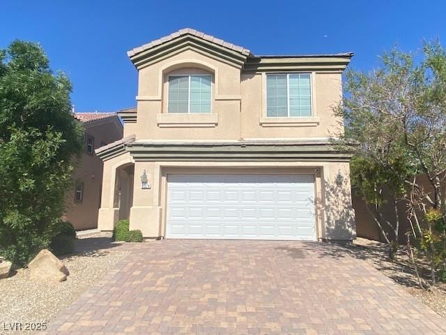 8374 Pioneer Way, Las Vegas, NV 89113 - traditional-style house featuring a garage, stucco siding, a tiled roof, and decorative driveway