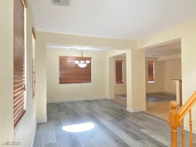 8374 Pioneer Way, Las Vegas, NV 89113 - empty room with a chandelier, visible vents, baseboards, and wood finished floors