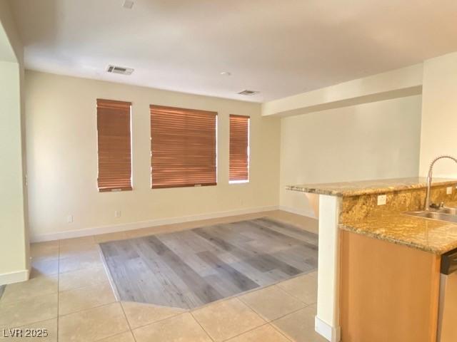 8374 Pioneer Way, Las Vegas, NV 89113 - unfurnished room with light tile patterned floors, baseboards, and bar with sink