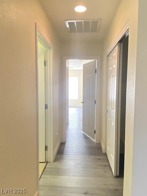 8374 Pioneer Way, Las Vegas, NV 89113 - hallway featuring visible vents, light wood-style flooring, and baseboards