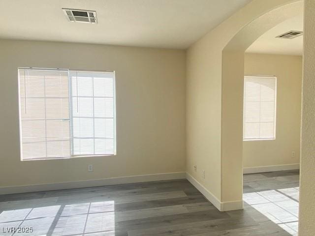 8374 Pioneer Way, Las Vegas, NV 89113 - spare room with visible vents, baseboards, arched walkways, and wood finished floors
